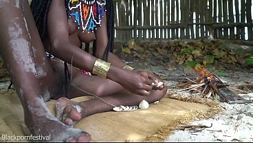 Beautiful tribe girl making traditional jewelery next to a firecamp